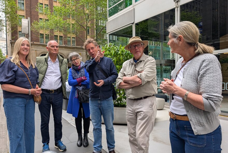 Small tour group standing in a courtyard, looking ahead.