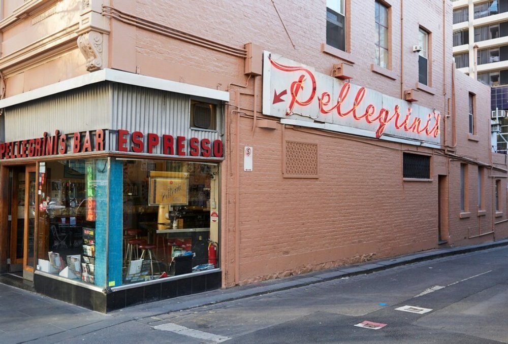 Street view of an Italian restaurant with a neon red sign.