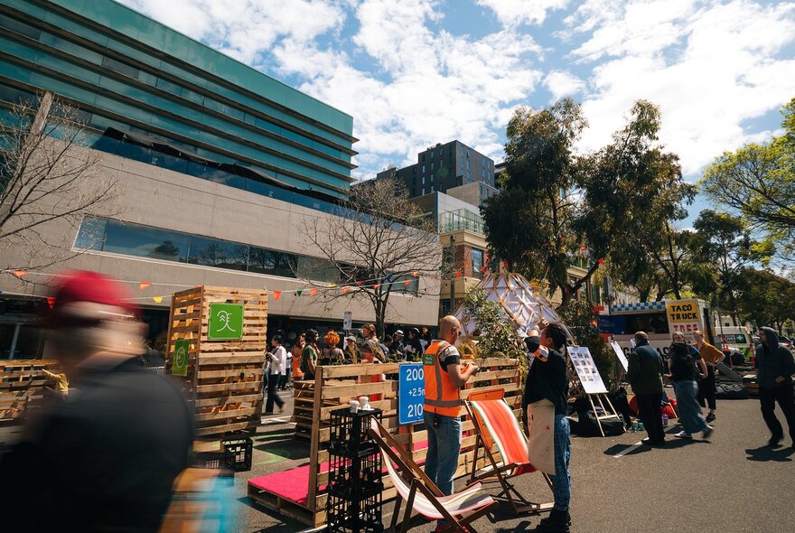 Cardigan Street closed to traffic with people milling around structures and displays.