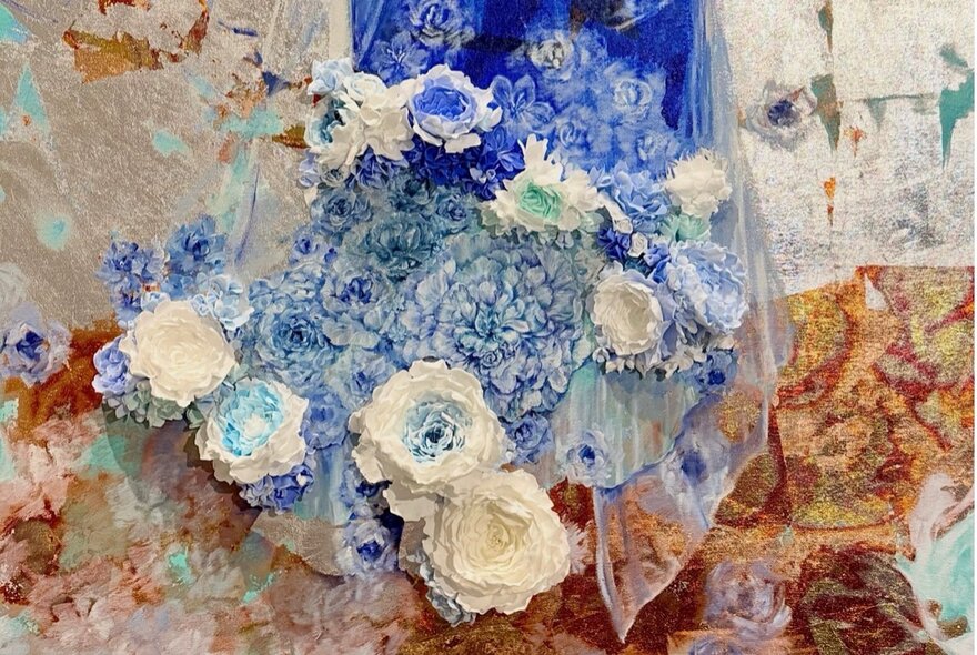 Abstract collage artwork of blue and white flowers against a tan and white background.