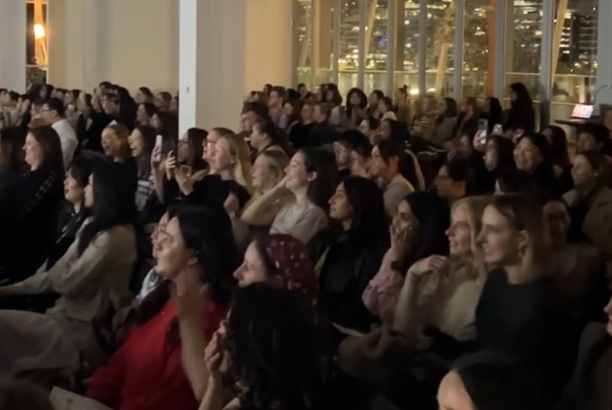 A seated audience of women.