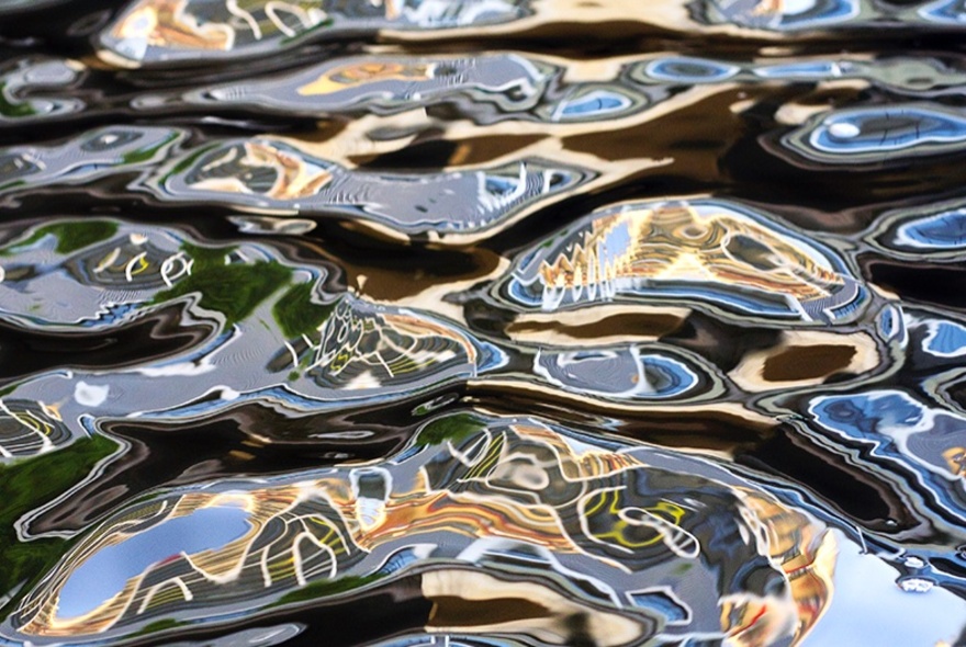 Highly reflective ripples on the surface of water with swirling patterns. 