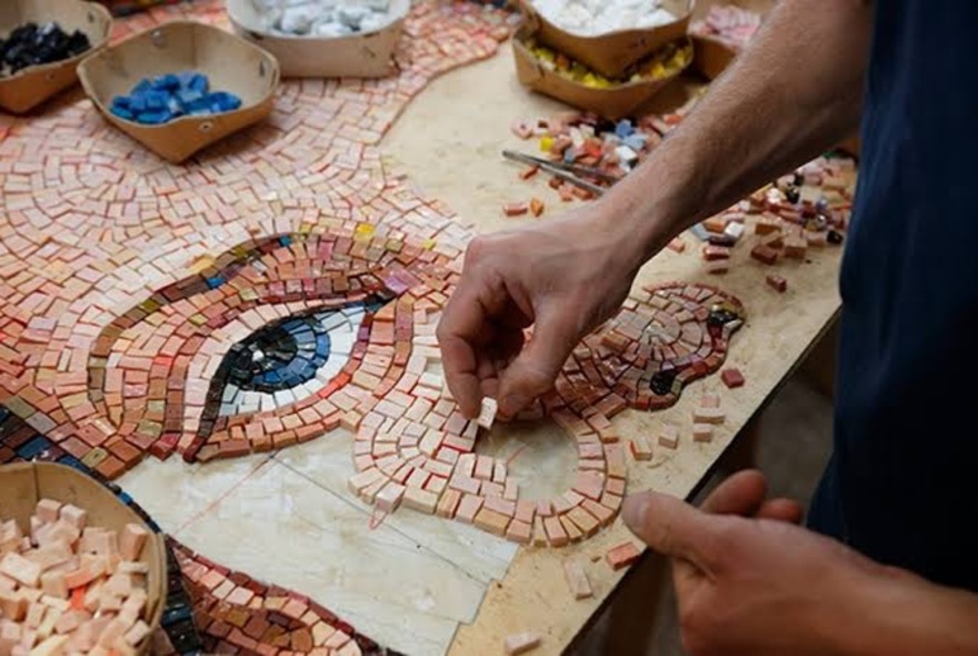Person making a moxaic of a face with prominent eye.