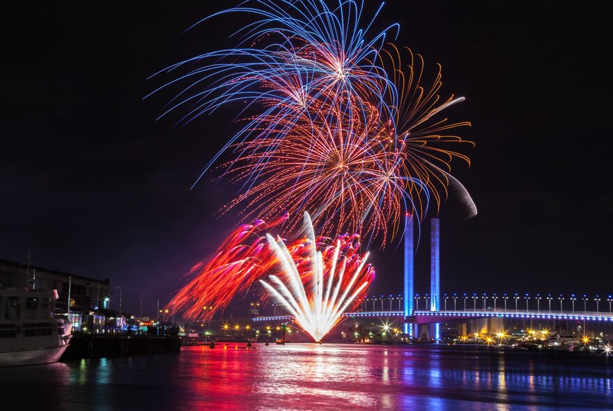 Fireworks on Bolte Bridge with reflections in the water.