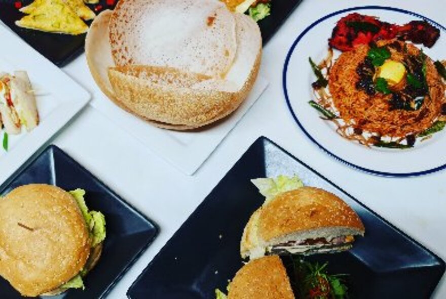 Selection of plates of food on a dining table.