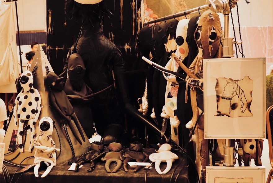 A collection of random hand-made dolls and statuettes at a market stall.