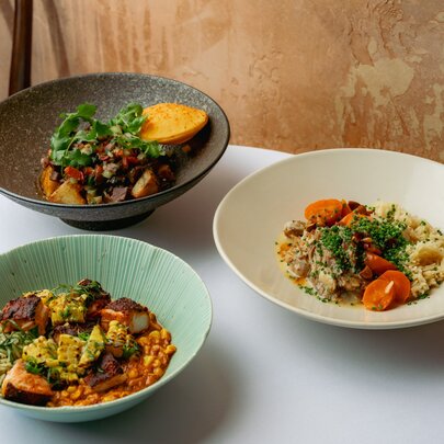 Three gourmet bowls with various fillings on a restaurant table.