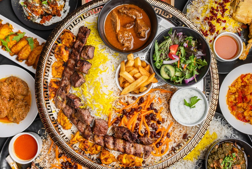 Looking directly down on a platter of middle eastern food with small bowls and condiments. 