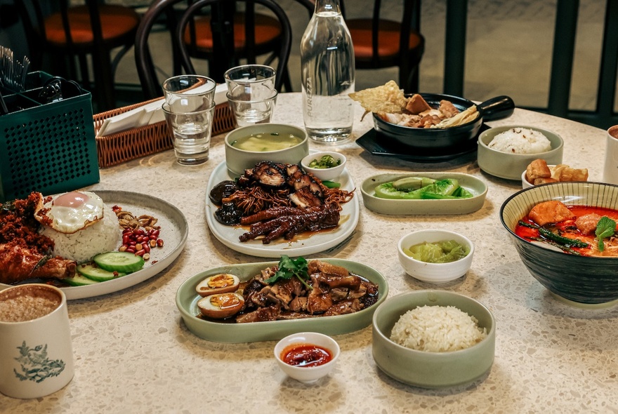 A table with assorted dishes of Malaysian street food.