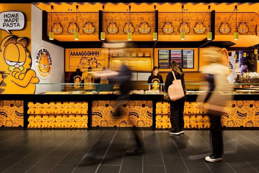 People queuing at a yellow pop-up pizza bar counter.
