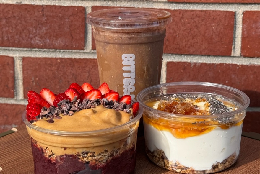 A smoothie and two acai bowls in clear plastic take-away containers.