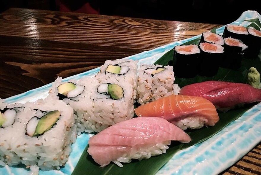 Long platter filled with seafood sushi.