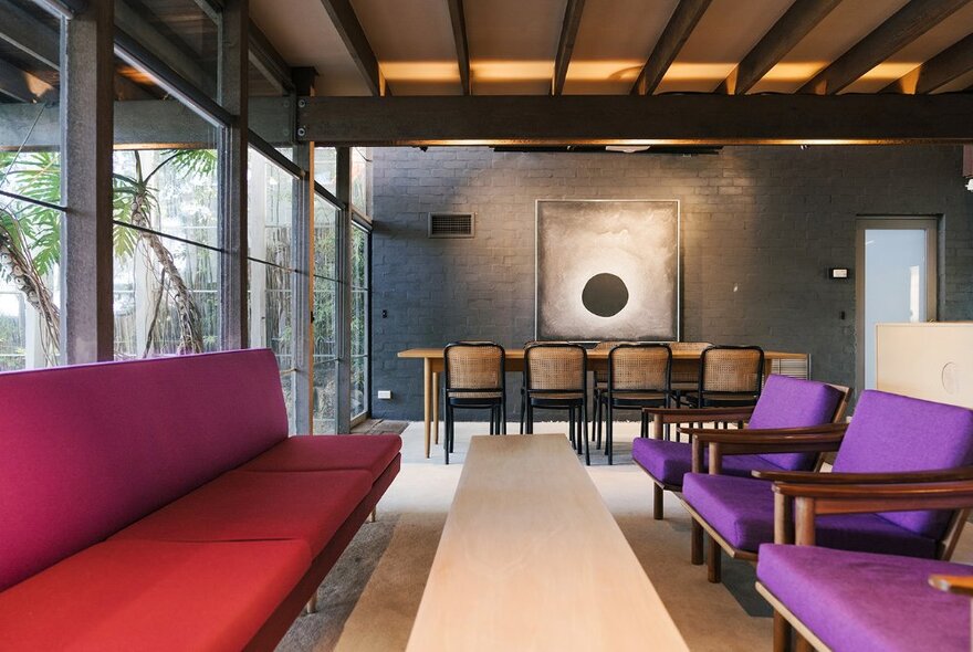 The retro interior of a 1950s home with purple and red chairs. 