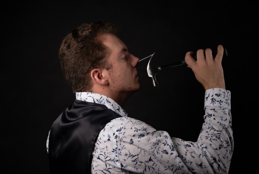 A performer singing into a microphone wearing a black waistcoat.