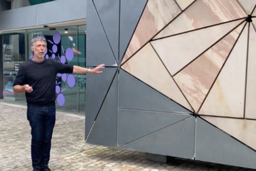 A tour guide pointing out detail at Federation Square.