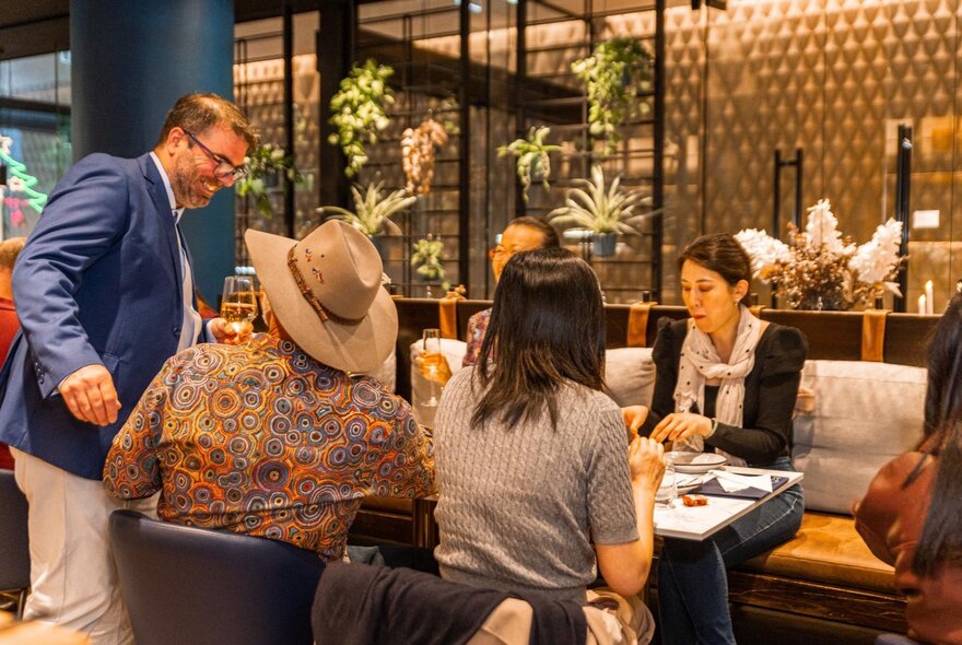 Friends seated around a table enjoying a meal inside a cafe.