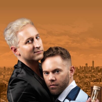 Two men in an embrace, holding an egg timer, against an orange backdrop of Melbourne.