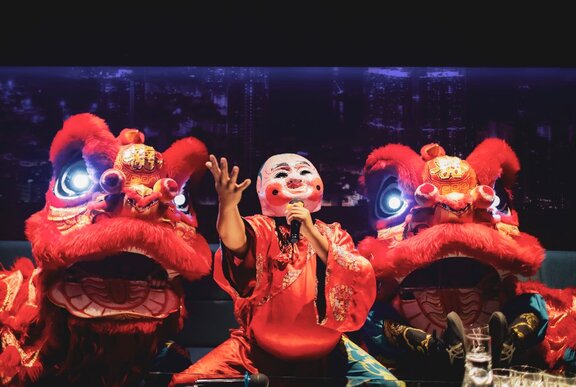 Lunar New Year performers in a mask and lion costume.