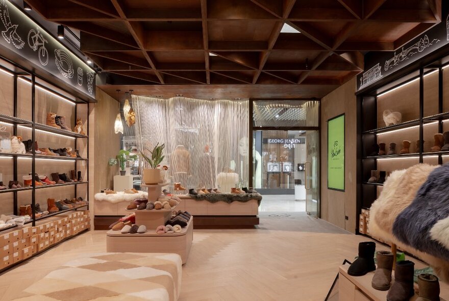 The interior of Yellow Earth at the Melbourne Emporium, with shelves on the sides showcasing slippers, and a beige ottoman in the middle of the store.