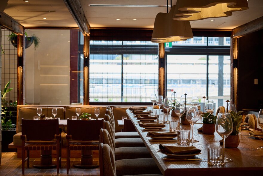 Hotel restaurant area with tables laid with cutlery and plates.