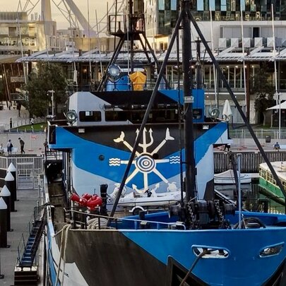 Blue and black boat docked at a pier in Docklands.