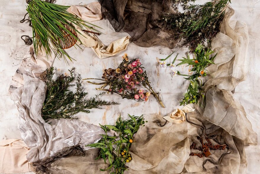 A collection of floral arrangements placed on a beige linen surface, seen from above.