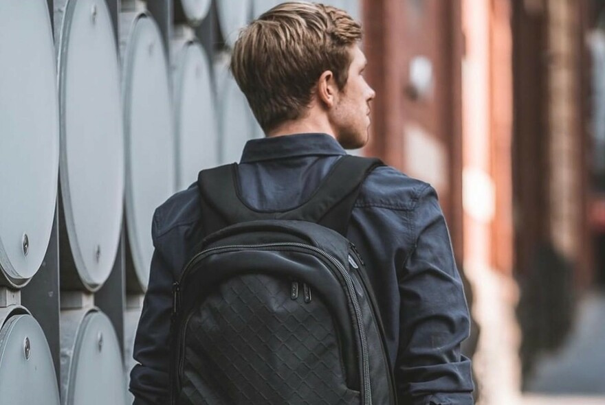 Man wearing black jacket and black daypack..