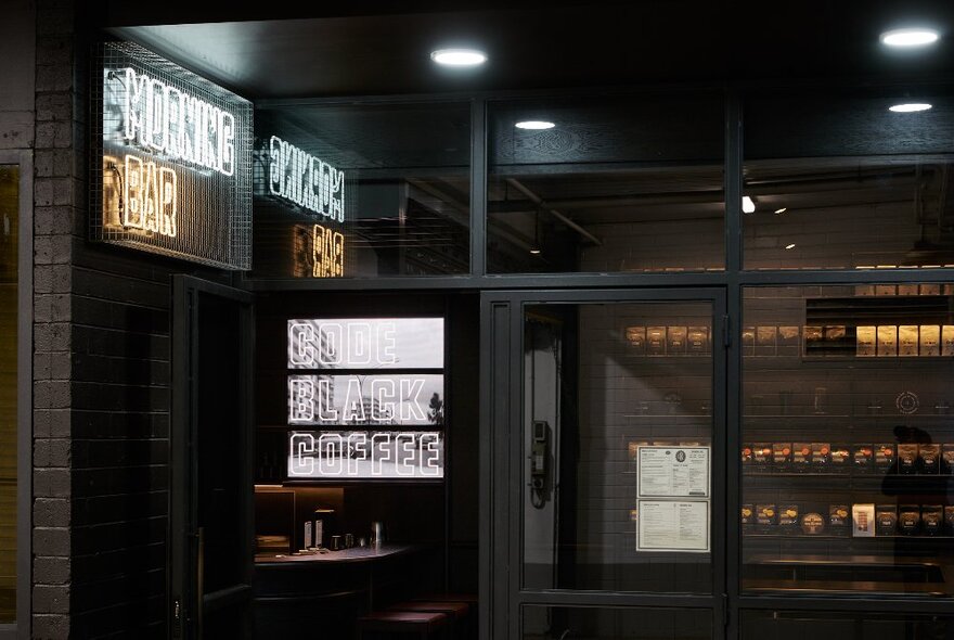 Code Black cafe exterior with black paintwork, neon sign and dim interior.