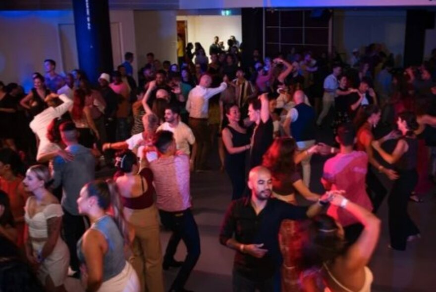 Crowded dance floor with people Latin dancing.