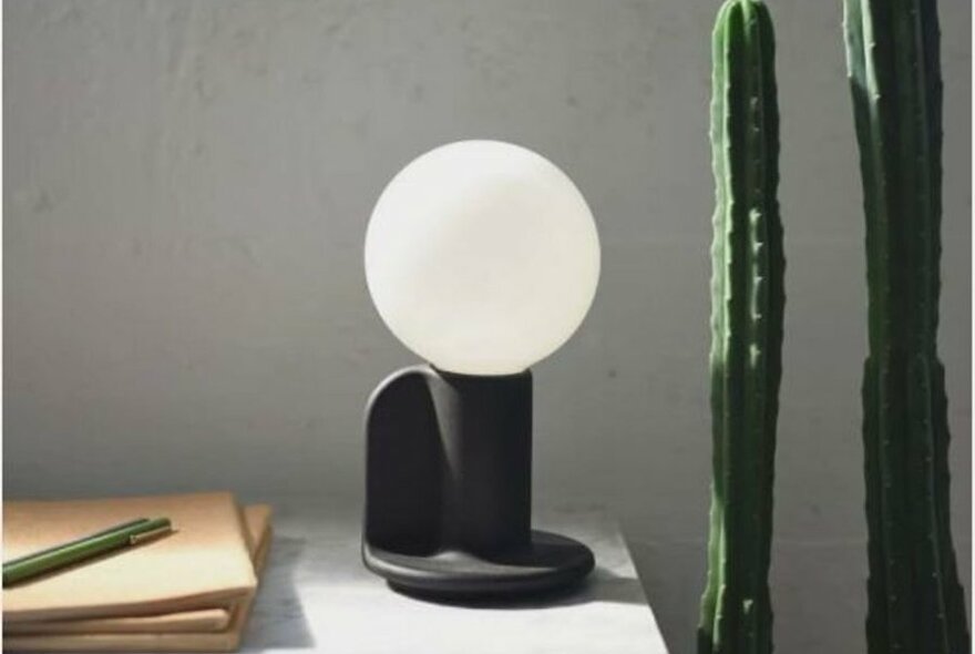 A white orb lamp on a black base.