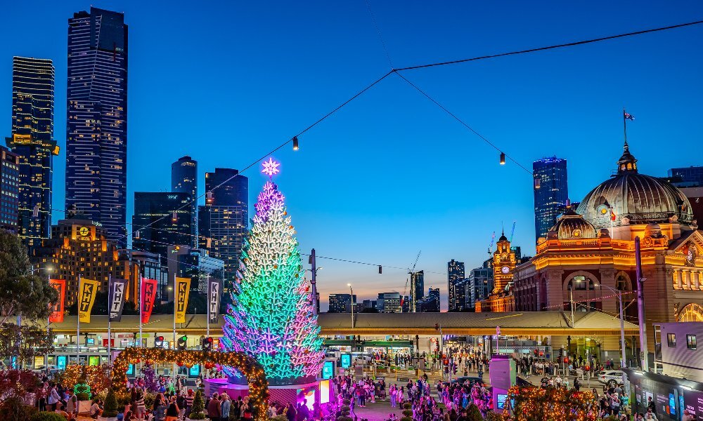 A town square with a neon Christmas tree. 