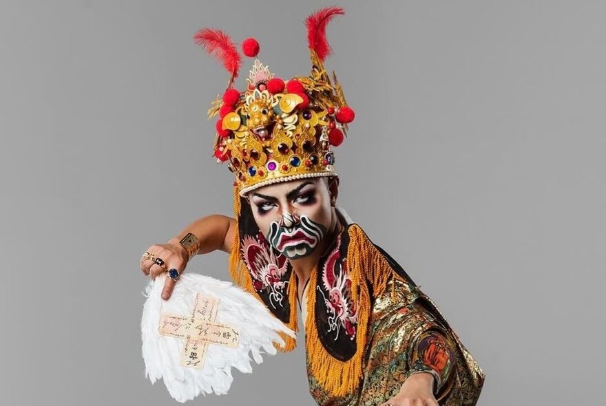 A traditional Taiwanese dancer with a gold crown, elaborate face paint and delicate costume.