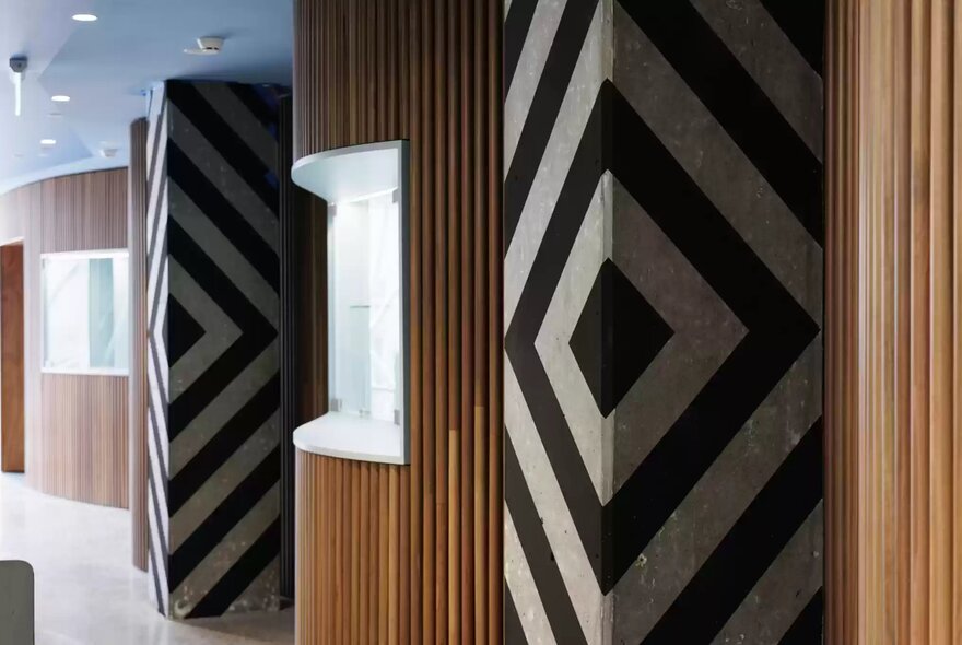 Interior details of Koorie Heritage Trust, featuring distinct chevron-patterned columns and timber wall panelling.