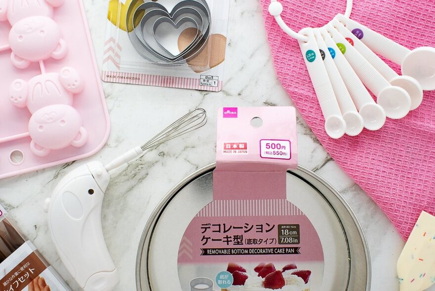 Assorted kitchen baking accessories in pink tones.