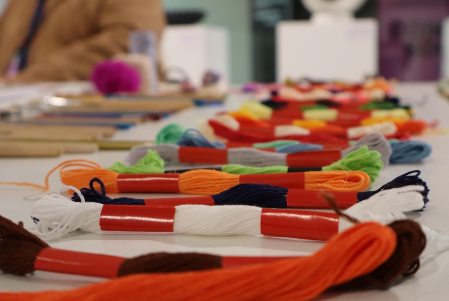 Skeins of wool lined up on a workbench.
