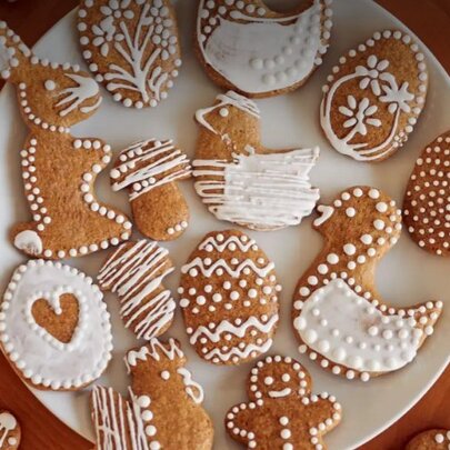 Easter-themed gingerbread cookies with white icing presented on a white plate.