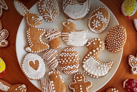 Easter-themed gingerbread cookies with white icing presented on a white plate.
