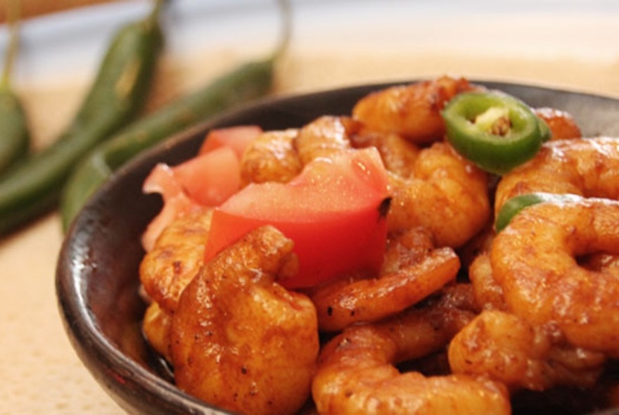 Prawn dish, topped with tomato and green chilli slices.