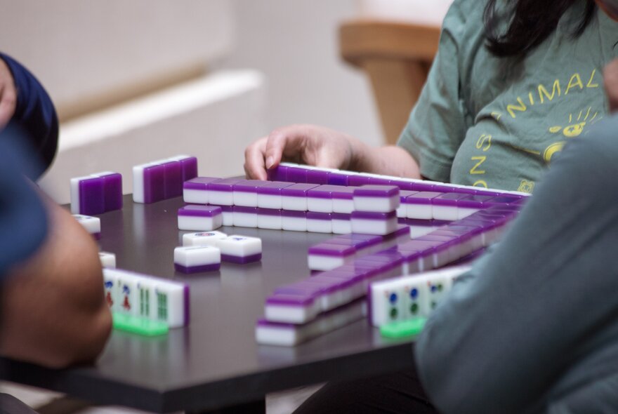 People seated around a table playing mahjong.