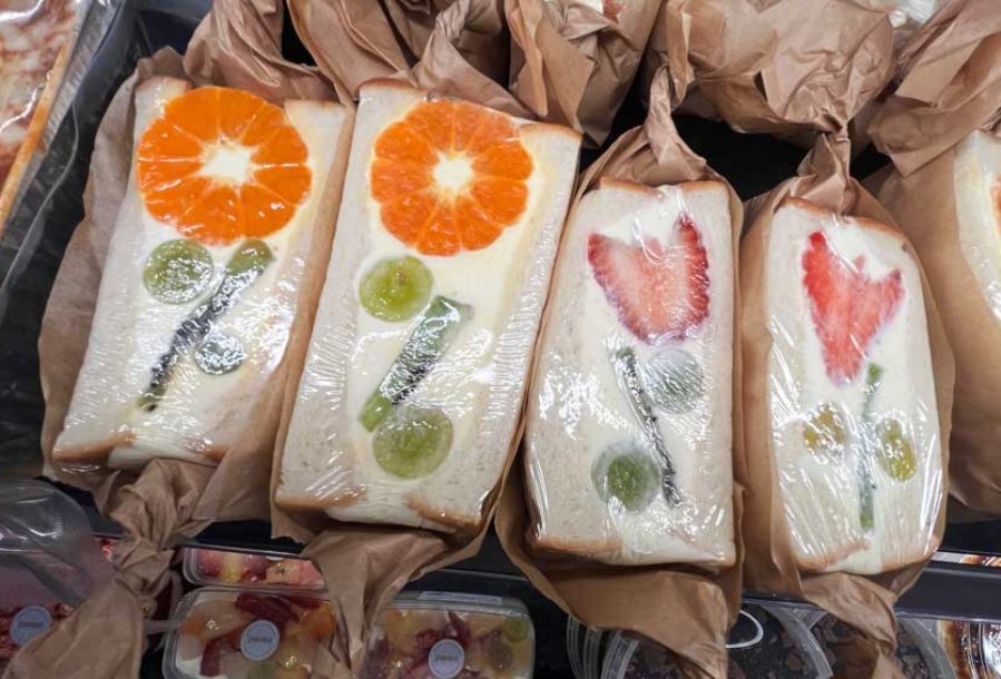 A row of dessert sandwiches with fruit cut in them to look like flowers
