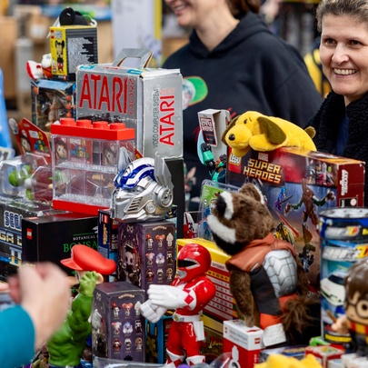 Person smiling at a collection of robot toys at a collectors fair.