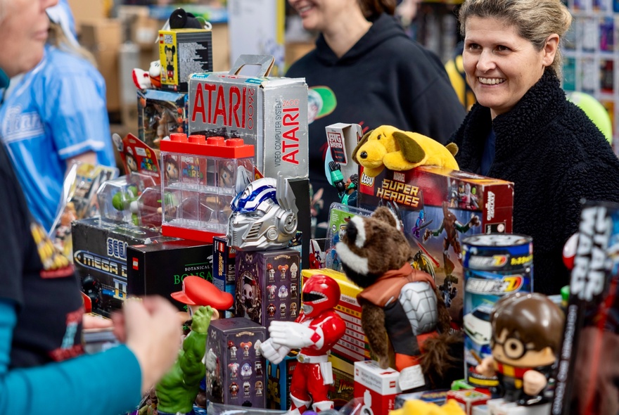 Person smiling at a collection of robot toys at a collectors fair.