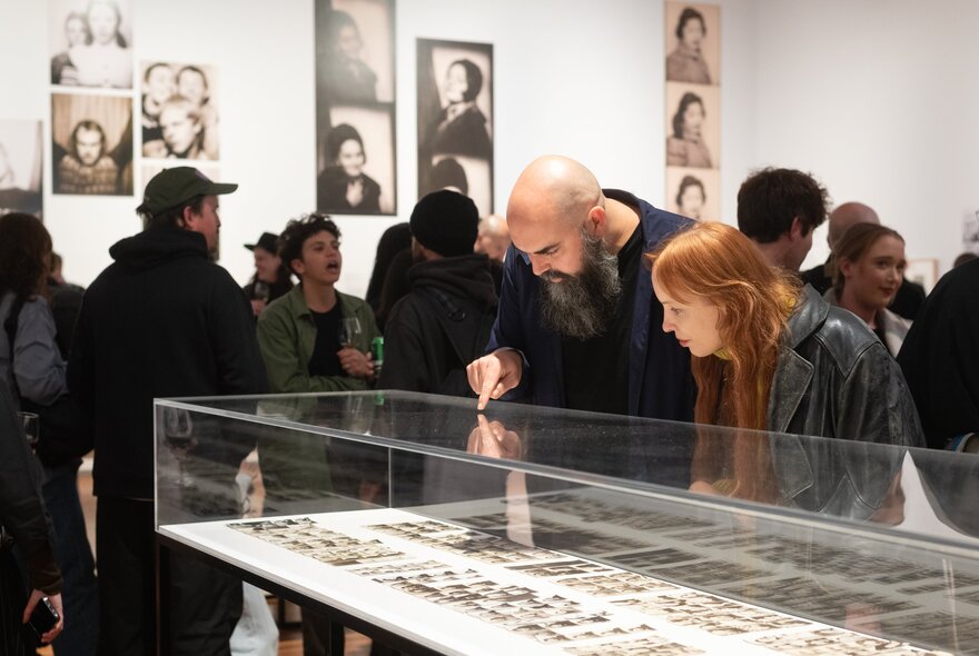 People viewing an exhibition in a busy gallery space.