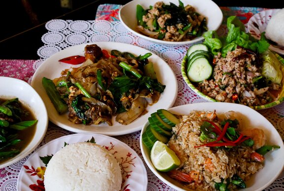 Plates of Thai food and plain rice.