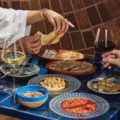 A table full of share plates and wine.