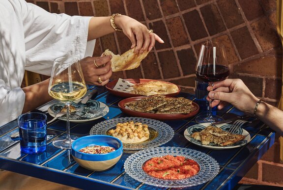 A table full of share plates and wine.