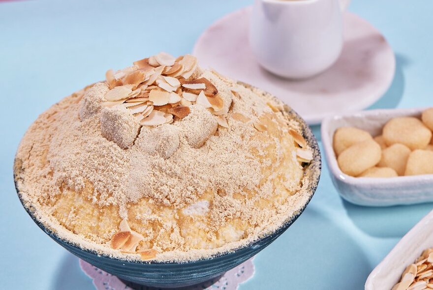 Korean style iced dessert in a bowl garnished with flaked nuts.