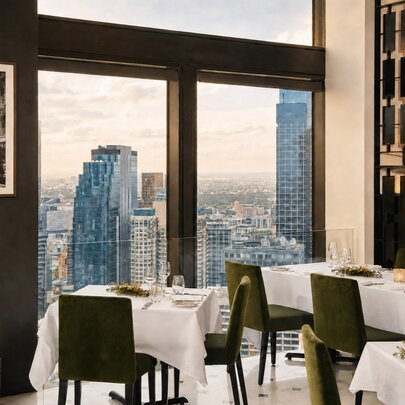 The dining room of No35 restaurant with large windows looking down at the skyline of Melbourne