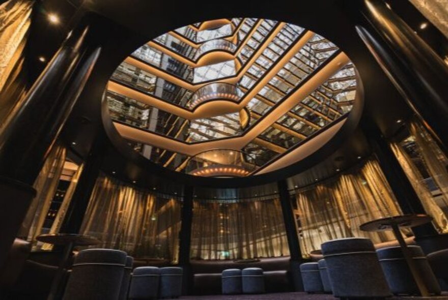 Looking up into the mirrored atrium at The Atrium on 35 bar, with small round bar tables and chairs in the lower space.
