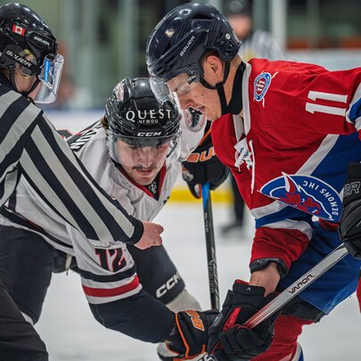 Three ice hockey players on the ice during a game.